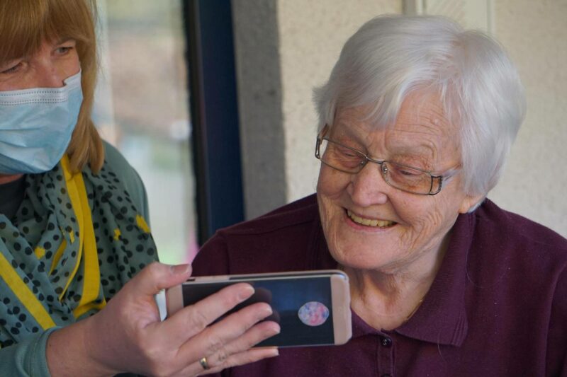 starsza osoba ogląda coś na smartfonie